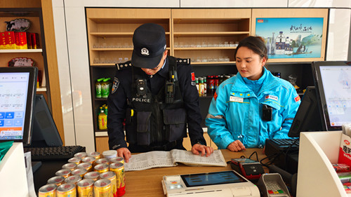 1772022300416159.jpg 图为民警对加油站台账记录进行检查.jpg