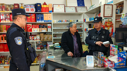 1772022317137442.jpg 图为民警对商铺报警器进行检查.jpg